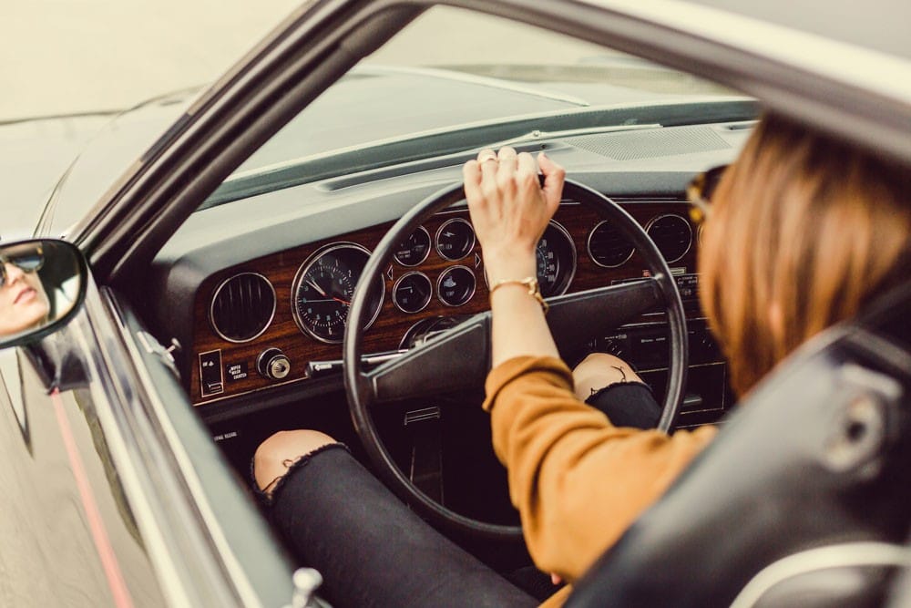 La REGO chica conduciendo en un coche vintage